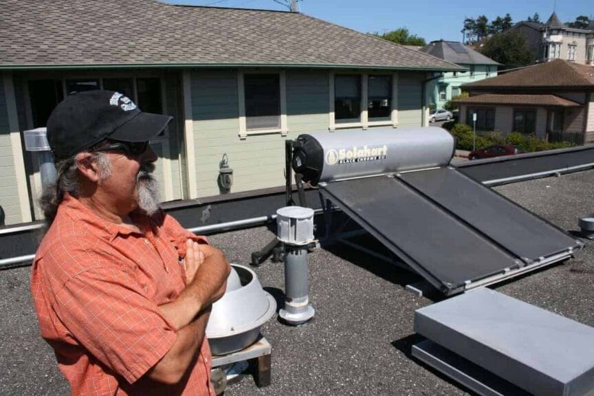 img 7576 Hot water solar systems. A man on a roof next to his system