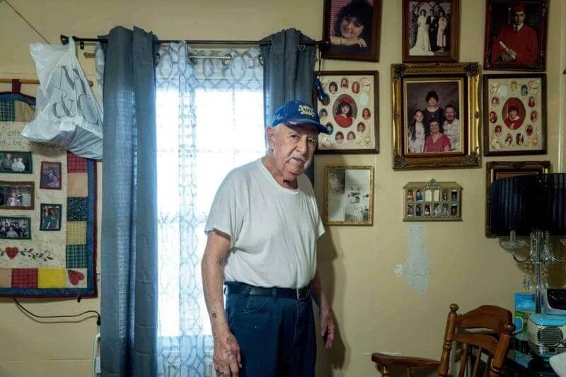 An elderly gentleman standing in his living room.