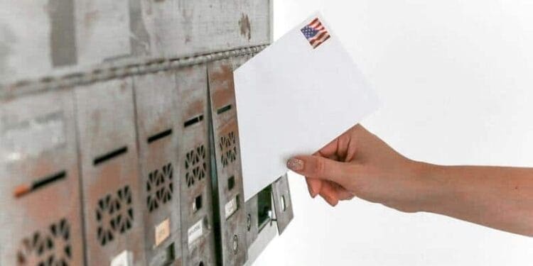 post office box 1 A hand puts a letter in a mailbox at the usps office