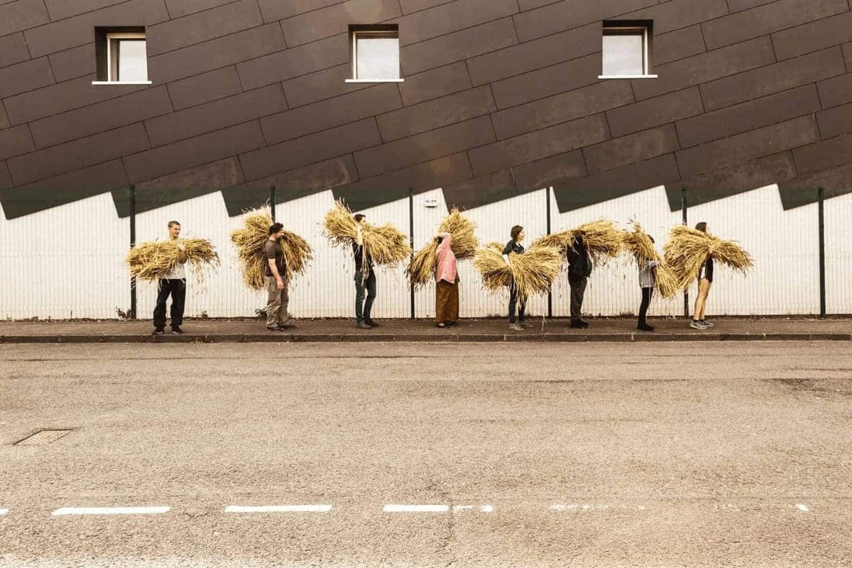 bakery staff carrying wheat People walking down the street carrying sheaves of wheat