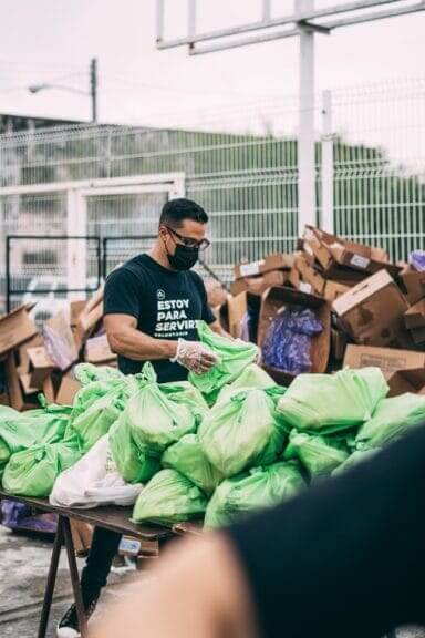 claudia raya nonprofit worker A man volunteering for a nonprofit sorts through donations.