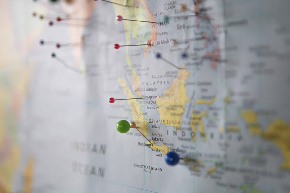 Isolationism. A map of the world on a wall with pins in it.