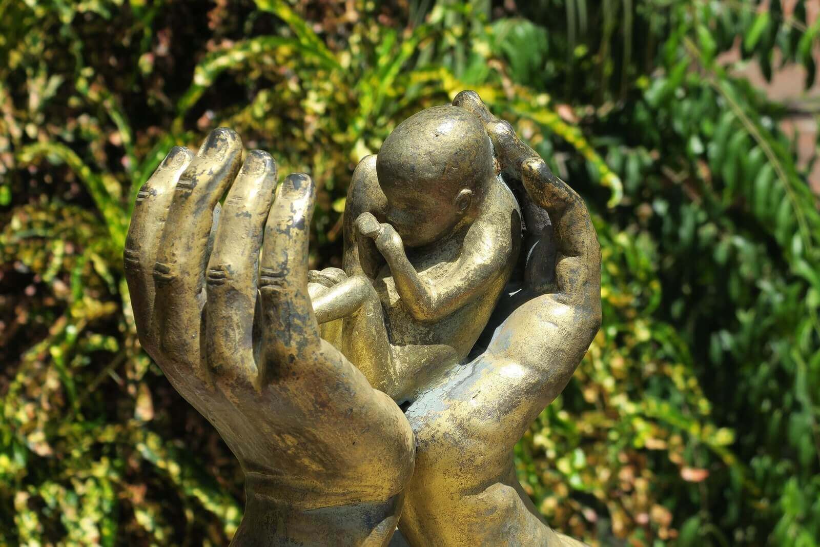 abortion h hach Sculpture of a baby between 2 hands