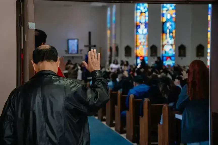 church scene A man raises his hand in prayer during mass at nuestra señora de la paz, on april 6, 2025, in milwaukee, wisconsin.
