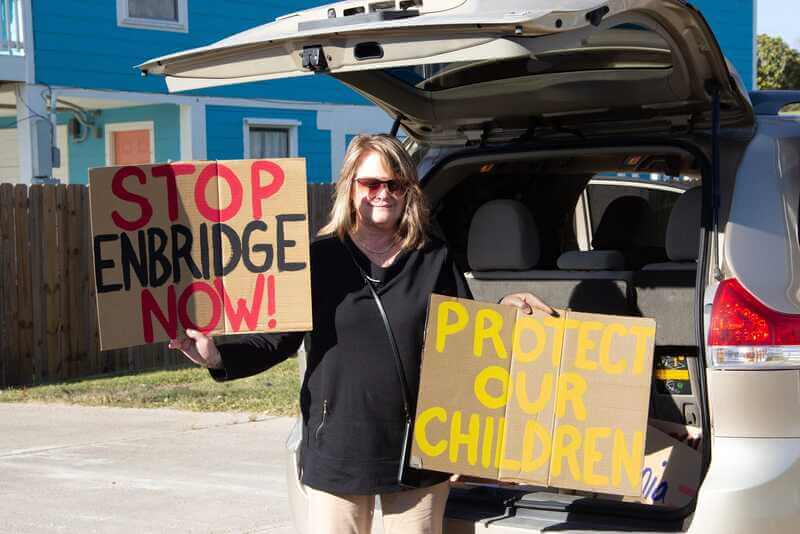 oil protester holding signs Texas oil protester holding signs
