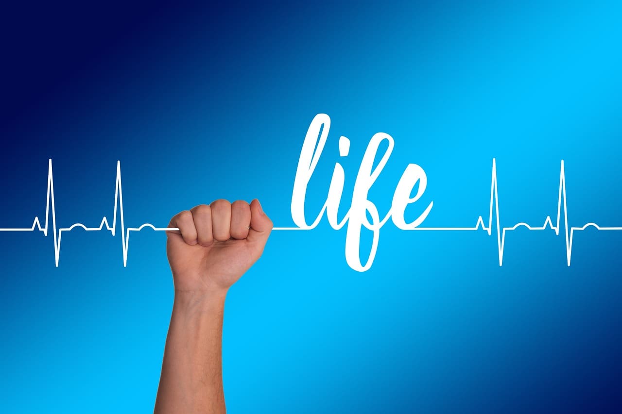 A hand holding a string with a heartbeat line
