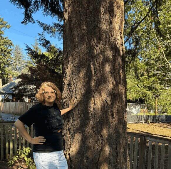 homeowner tree 1 1 Homeowner standing beside a tree.