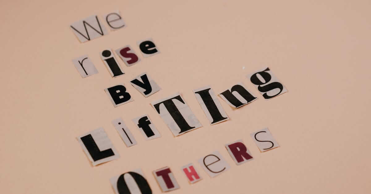 Cutout letters forming an inspirational quote on a beige background, encouraging positivity.
