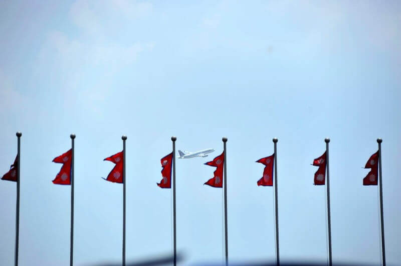 flags plane Row of flags with a plane taking off in the background.