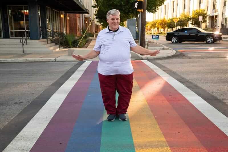 man on rainbow crosswalk James poindexter, pride san antonio board member, at the rainbow crosswalk