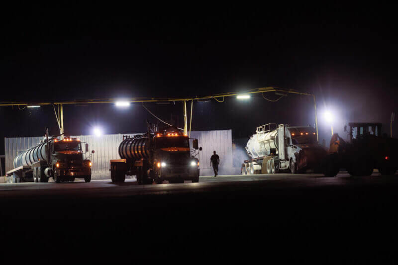 pitted against waste trucks Trucks dumping waste at night