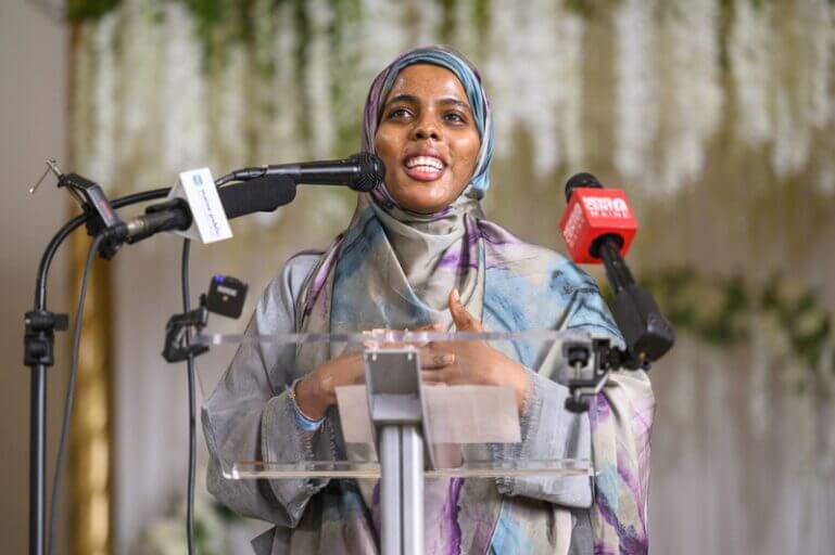 maine ice protest speaker Amran osman speaks the anti-ice rally in the agora palace event center in lewiston on jan. 24, 2026. (photo by jim neuger/ maine morning star)