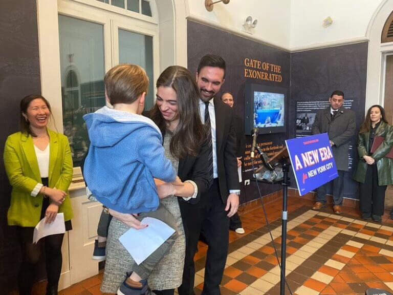 Emily liss holding her son at the announcement that kamar samuels will be the new schools chancellor. Director of anti-extremism t hunt dsa for third way