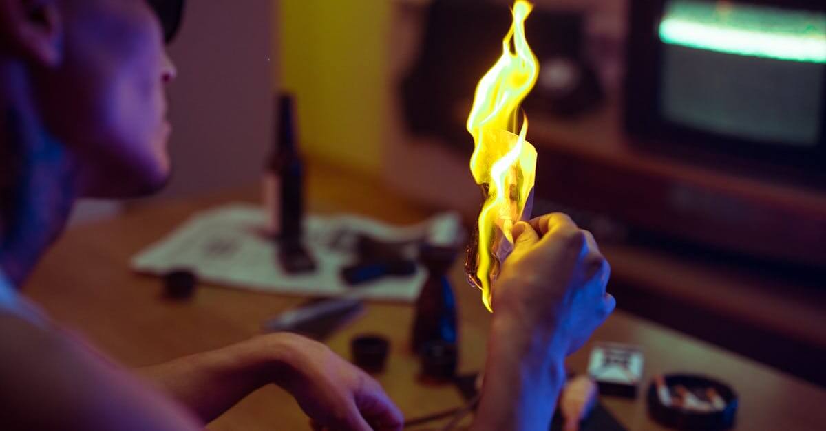pexels photo 8766634 8766634 A person holding a burning piece of paper indoors, creating a dramatic and moody atmosphere. Project 2025 is burning down the country.
