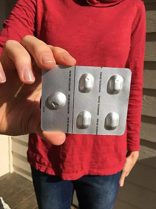 abortion pills pack Hand holding abortion pills illegal to mail under the comstock act