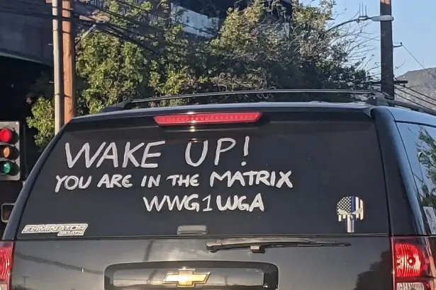 Qanon writing about deep state on rear window of an suv