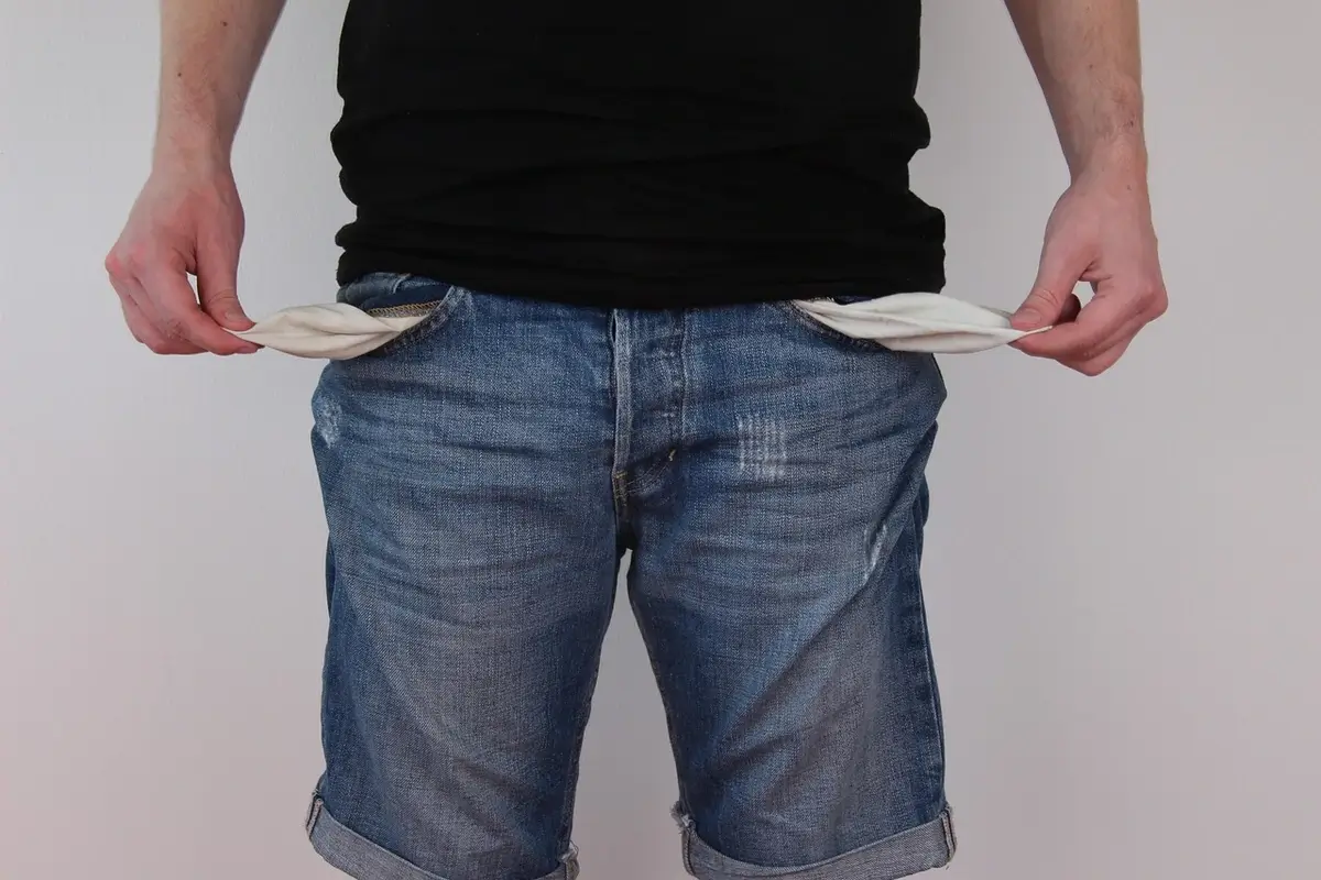 2027 budget cuts benefits to fund war. A man showing empty pockets