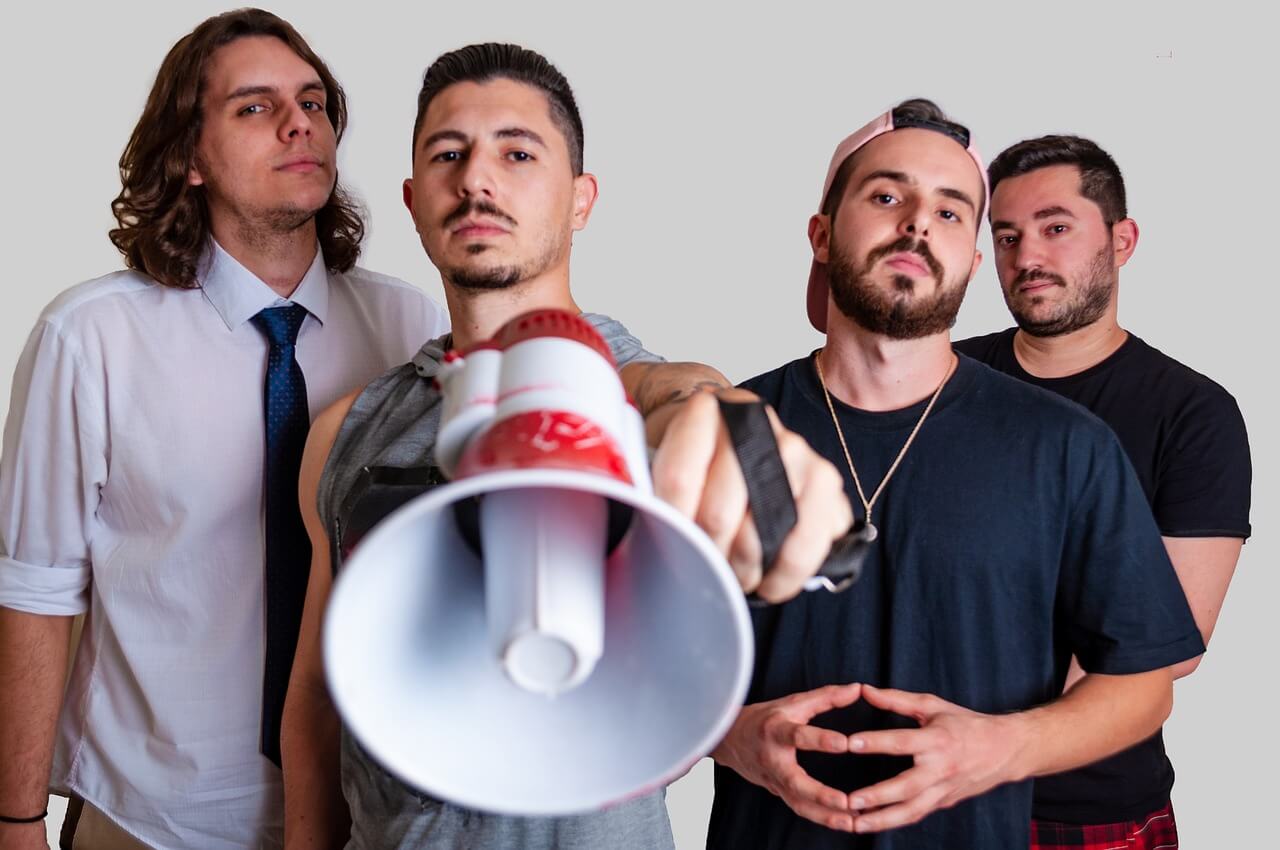 activist partnership 4 men in a group with one holding a bullhorn