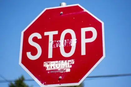 Stop sign with trump added underneath the word stop