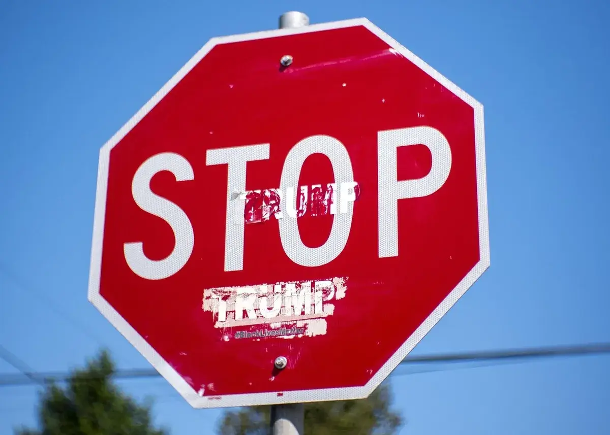 Stop sign with trump added underneath the word stop