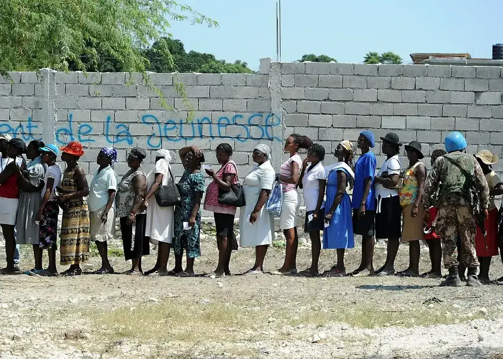 Haitian women wait in l8ne for aid