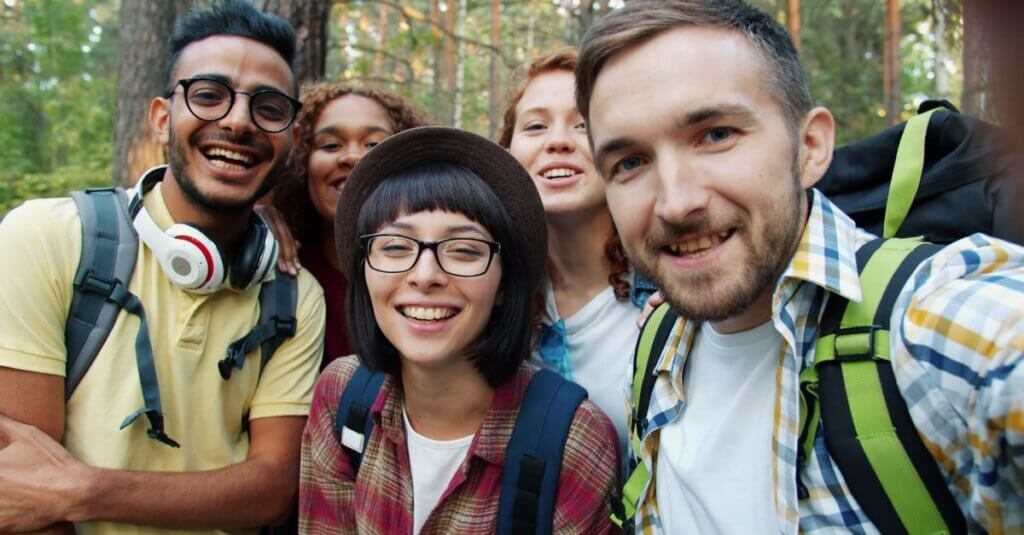 Anti-hate community Happy friends taking a selfie during a forest hike, enjoying nature and companionship.