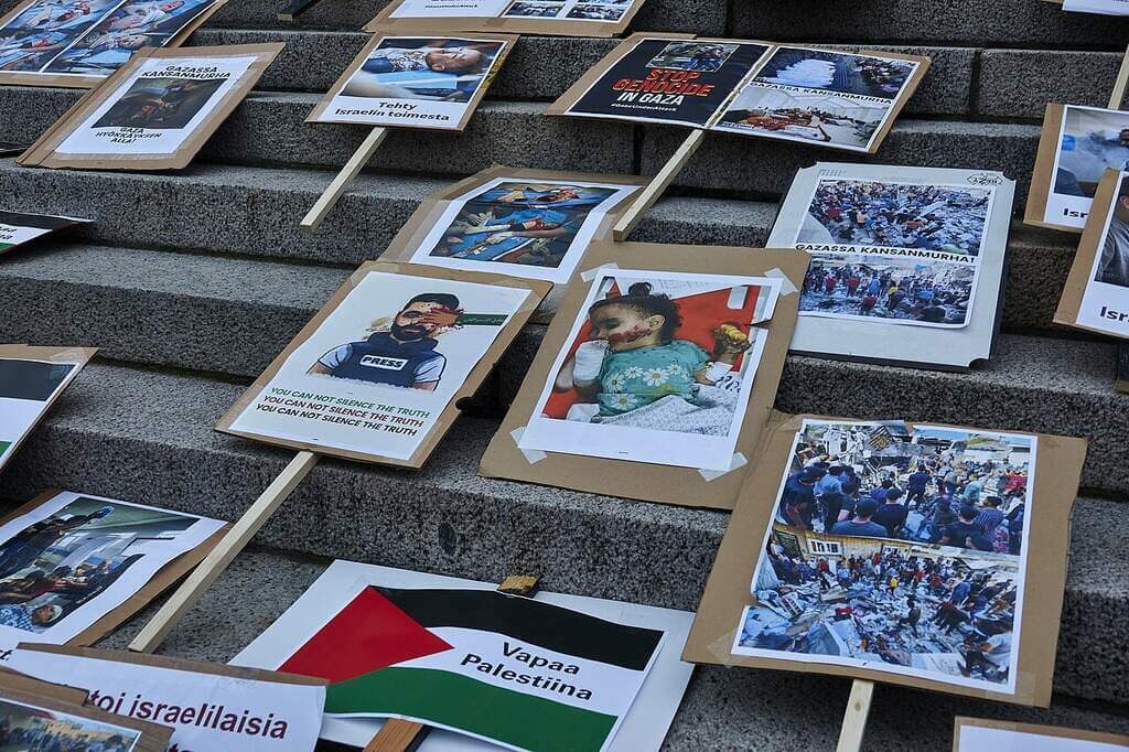 stop the genocide children Signs from a stop the genocide protest with images of children injured or killed in gaza.