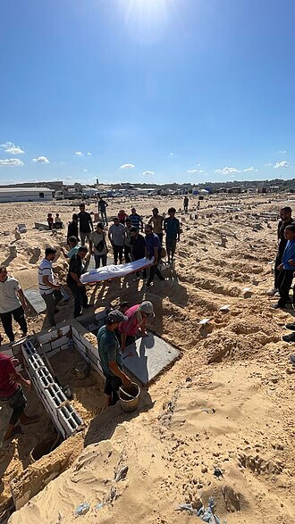 Palestinians burying the dead.