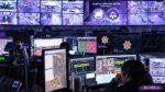 Fbi data breach. Tech room with agents seated at computer monitors
